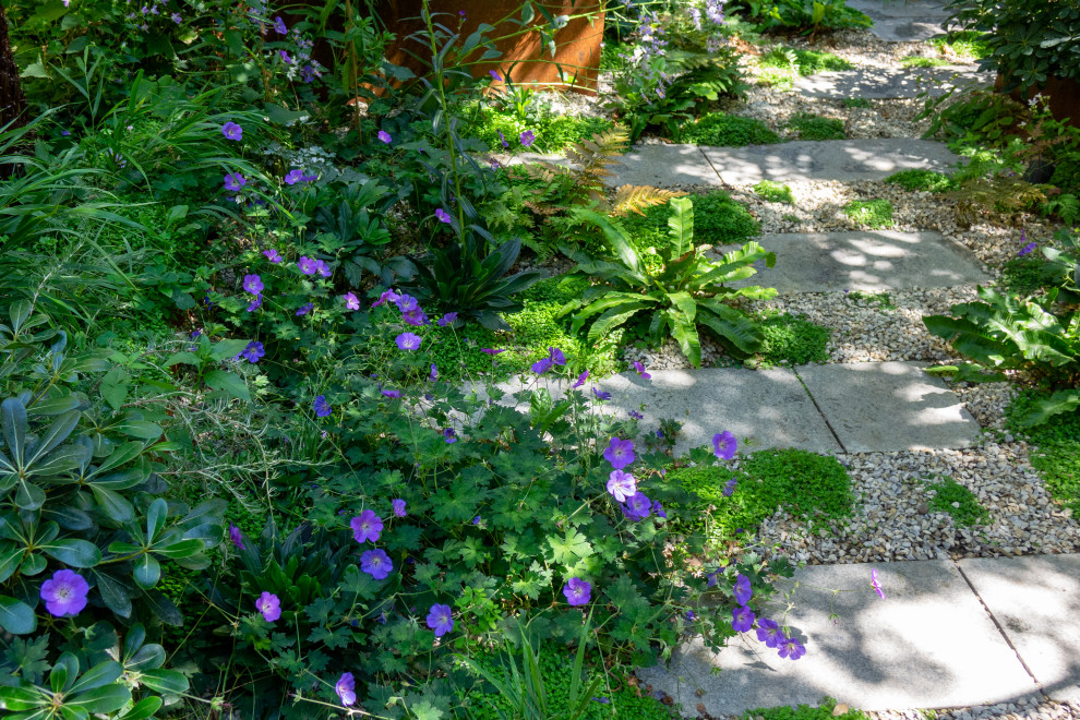 Immagine di un piccolo giardino contemporaneo in ombra dietro casa in estate con un ingresso o sentiero e pavimentazioni in pietra naturale