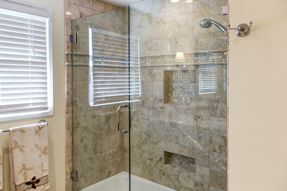 Inspiration for a mid-sized traditional 3/4 bathroom in Los Angeles with an undermount sink, furniture-like cabinets, medium wood cabinets, marble benchtops, an alcove tub, a shower/bathtub combo, a one-piece toilet, beige tile, beige walls, porcelain floors and stone slab.