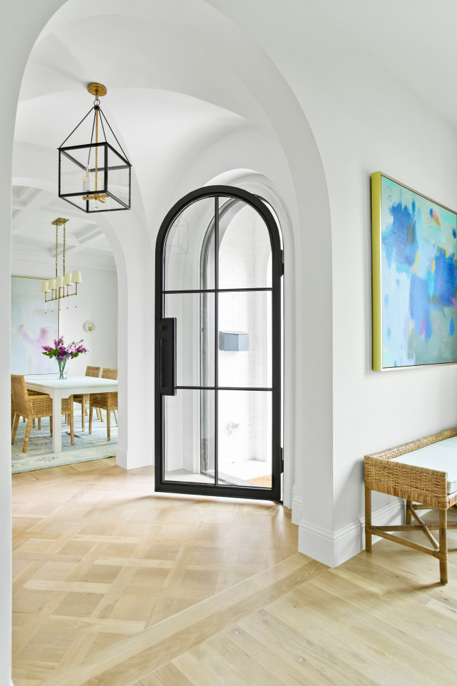 Foyer - large transitional light wood floor and brown floor foyer idea in Dallas with white walls and a metal front door