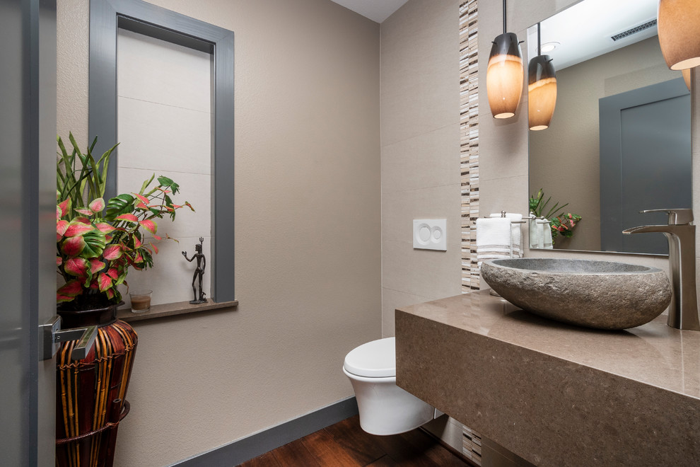 Inspiration for a small contemporary powder room in San Francisco with a wall-mount toilet, beige tile, porcelain tile, beige walls, dark hardwood floors, a vessel sink, engineered quartz benchtops, brown floor and brown benchtops.