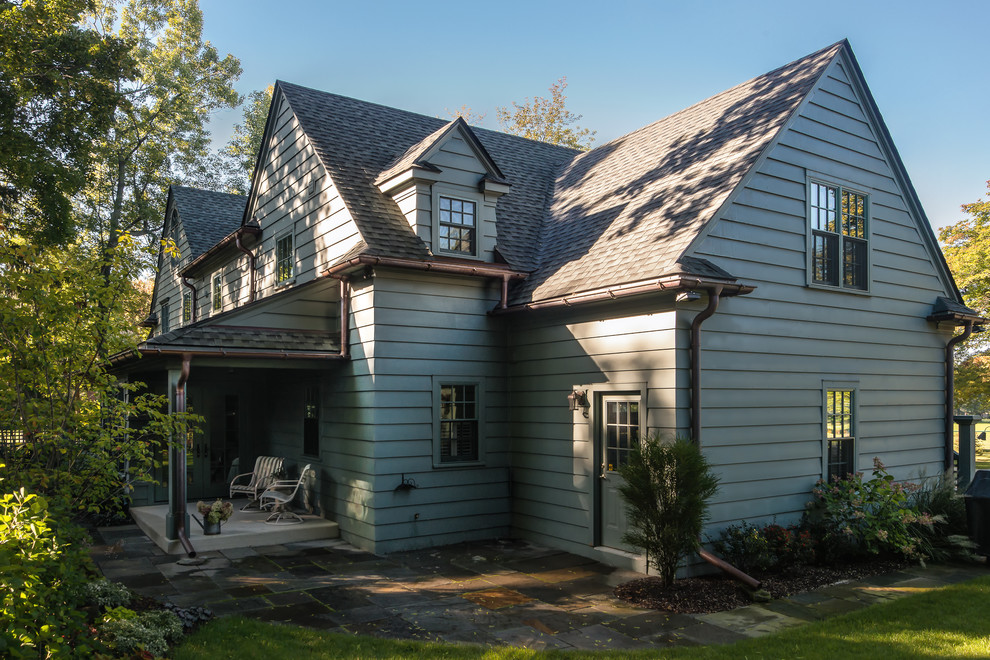 This is an example of an expansive traditional two-storey green house exterior in Detroit with wood siding, a gable roof and a shingle roof.