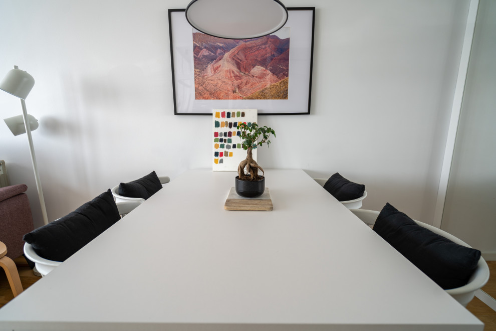 Réalisation d'une salle à manger ouverte sur le salon urbaine de taille moyenne avec un mur blanc, un sol en bois brun, une cheminée standard et un manteau de cheminée en métal.