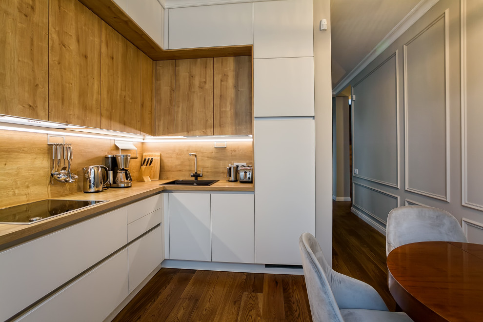 Foto på ett stort skandinaviskt brun kök, med en enkel diskho, luckor med glaspanel, vita skåp, laminatbänkskiva, brunt stänkskydd, svarta vitvaror, målat trägolv och brunt golv