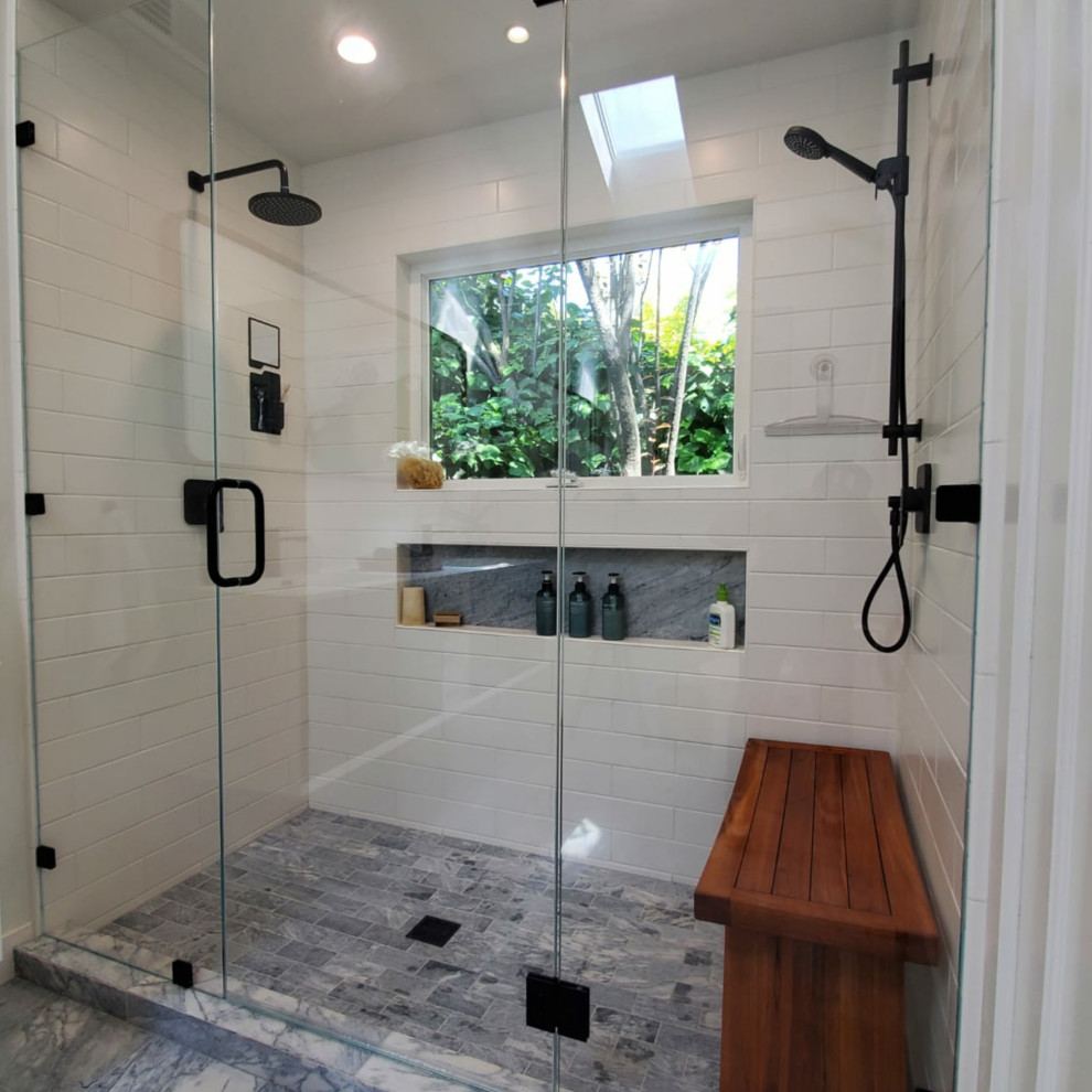 This is an example of a mid-sized modern master bathroom in San Francisco with flat-panel cabinets, white cabinets, an undermount tub, a double shower, a one-piece toilet, white tile, subway tile, white walls, porcelain floors, an undermount sink, engineered quartz benchtops, grey floor, a hinged shower door, white benchtops, a shower seat, a double vanity, a floating vanity and vaulted.