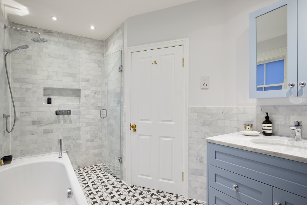 Idéer för stora funkis badrum för barn, med blå skåp, ett platsbyggt badkar, en öppen dusch, en toalettstol med separat cisternkåpa, grå kakel, ett integrerad handfat, marmorbänkskiva och dusch med gångjärnsdörr