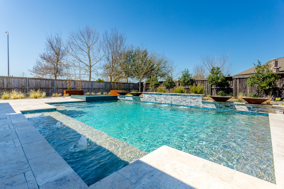 Aménagement d'une grande piscine arrière éclectique rectangle avec des pavés en pierre naturelle.