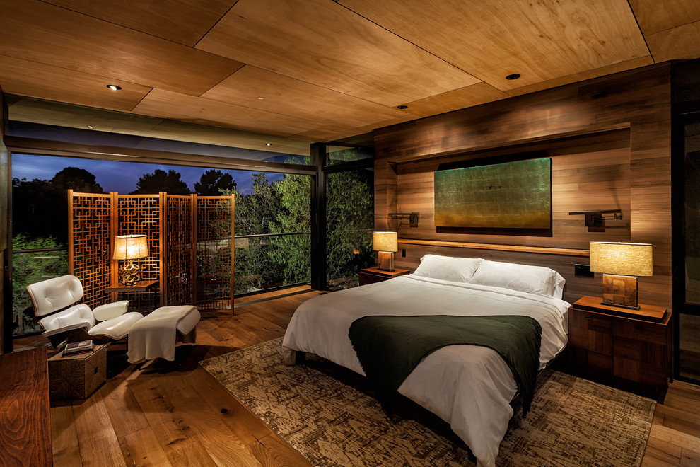 This is an example of an asian master bedroom in Orange County with brown walls, dark hardwood floors and brown floor.
