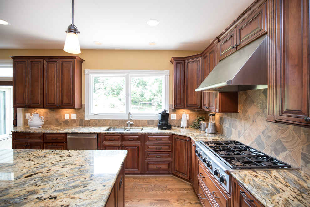 Inspiration for a mid-sized transitional u-shaped medium tone wood floor eat-in kitchen remodel in DC Metro with an undermount sink, raised-panel cabinets, dark wood cabinets, granite countertops, beige backsplash, stone tile backsplash, stainless steel appliances and an island