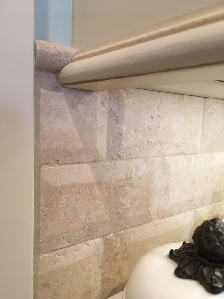 Inspiration for a large transitional galley porcelain tile enclosed kitchen remodel with an undermount sink, raised-panel cabinets, distressed cabinets, granite countertops, beige backsplash, stone tile backsplash, stainless steel appliances and a peninsula