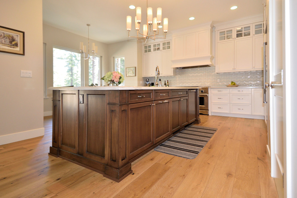 Inspiration for a mid-sized transitional l-shaped medium tone wood floor eat-in kitchen remodel with an undermount sink, recessed-panel cabinets, dark wood cabinets, granite countertops, glass tile backsplash, stainless steel appliances, an island and gray backsplash