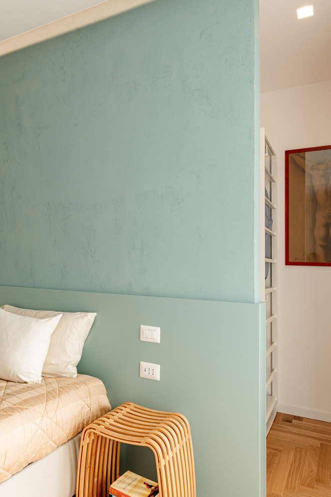 Exemple d'une chambre parentale tendance avec un mur bleu et parquet clair.