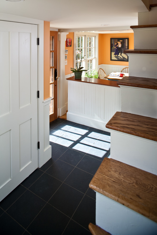 Inspiration for a mid-sized traditional mudroom in Boston with orange walls and slate floors.