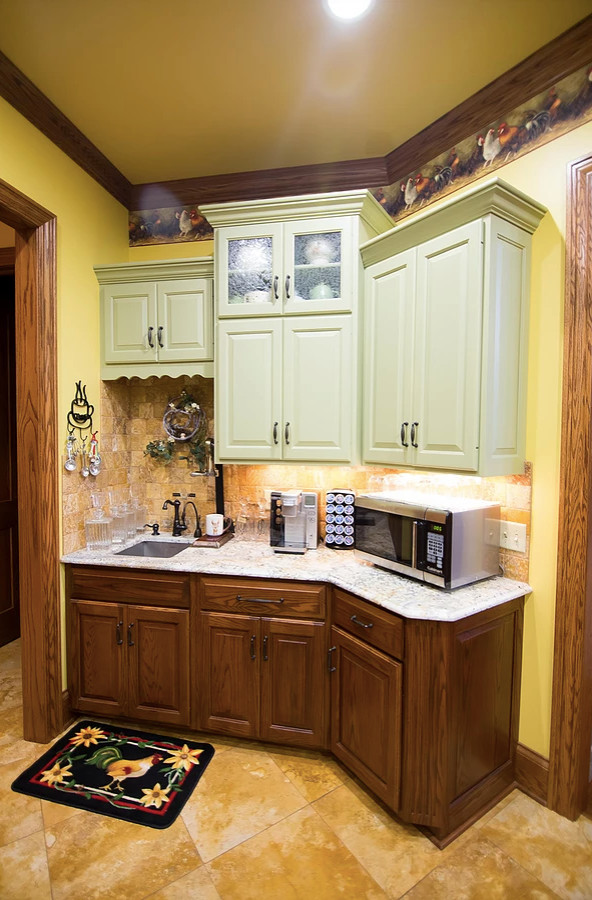 Large mountain style u-shaped porcelain tile and beige floor eat-in kitchen photo with an undermount sink, raised-panel cabinets, green cabinets, granite countertops, beige backsplash, porcelain backsplash, stainless steel appliances, an island and multicolored countertops