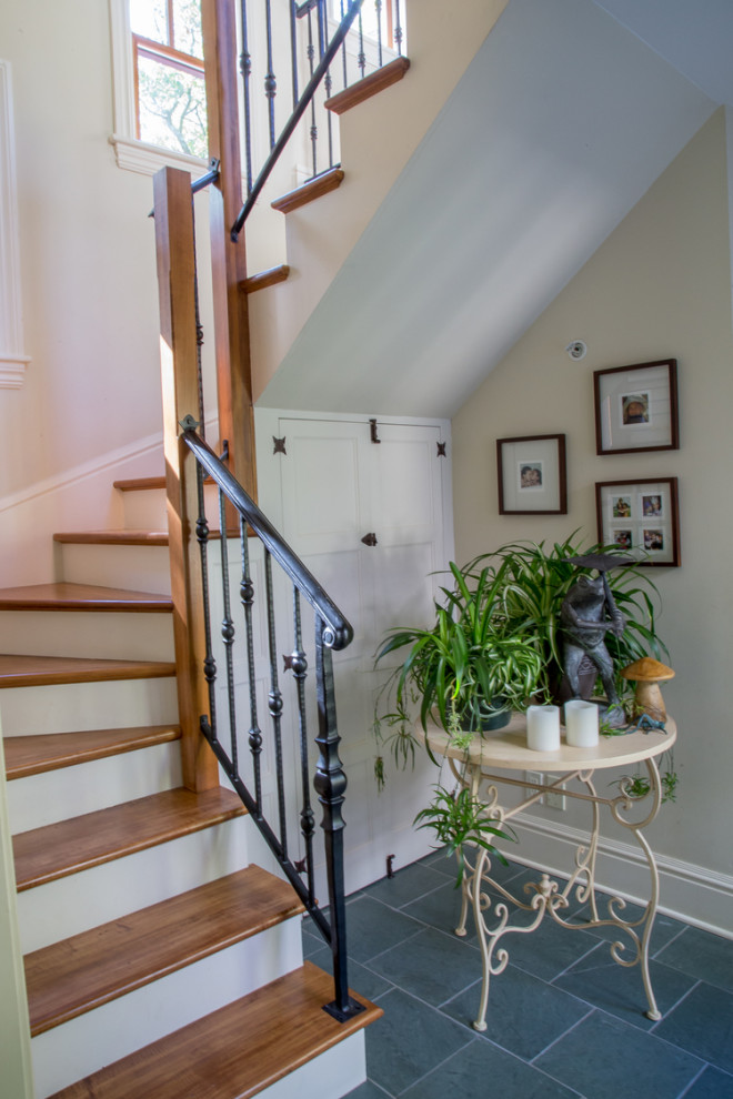 На фото: п-образная лестница в стиле неоклассика (современная классика) с деревянными ступенями, крашенными деревянными подступенками и металлическими перилами