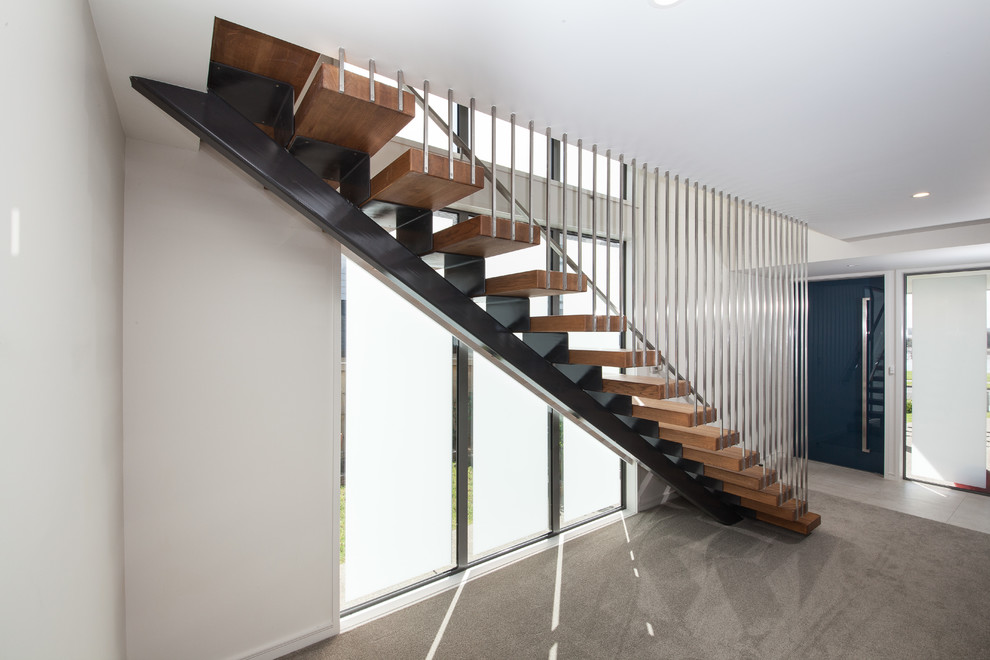 Mid-sized modern wood straight staircase in Auckland with open risers and metal railing.