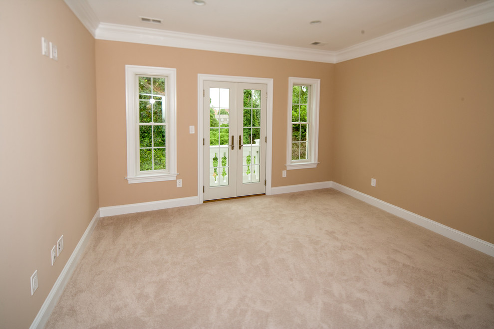 Photo of an expansive transitional bedroom in DC Metro with beige walls and carpet.