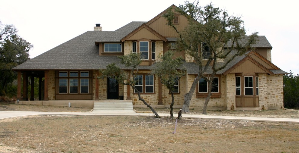 Photo of a large country two-storey beige house exterior in Austin with a gable roof, mixed siding and a shingle roof.