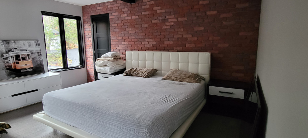 Идея дизайна: хозяйская спальня в стиле лофт с красными стенами, паркетным полом среднего тона, коричневым полом и кирпичными стенами