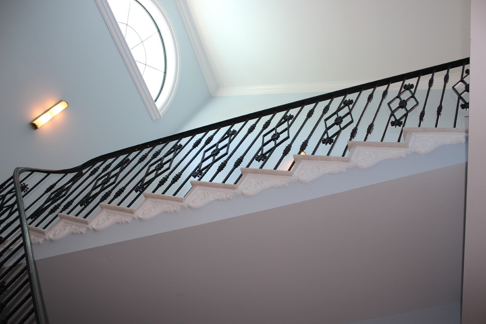 Источник вдохновения для домашнего уюта: большая лестница в стиле неоклассика (современная классика) с мраморными ступенями, подступенками из мрамора и металлическими перилами