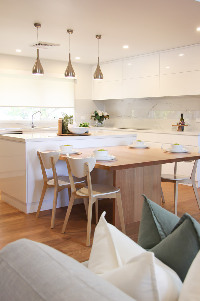 Beach style open plan dining in Sydney with white walls, medium hardwood floors and brown floor.