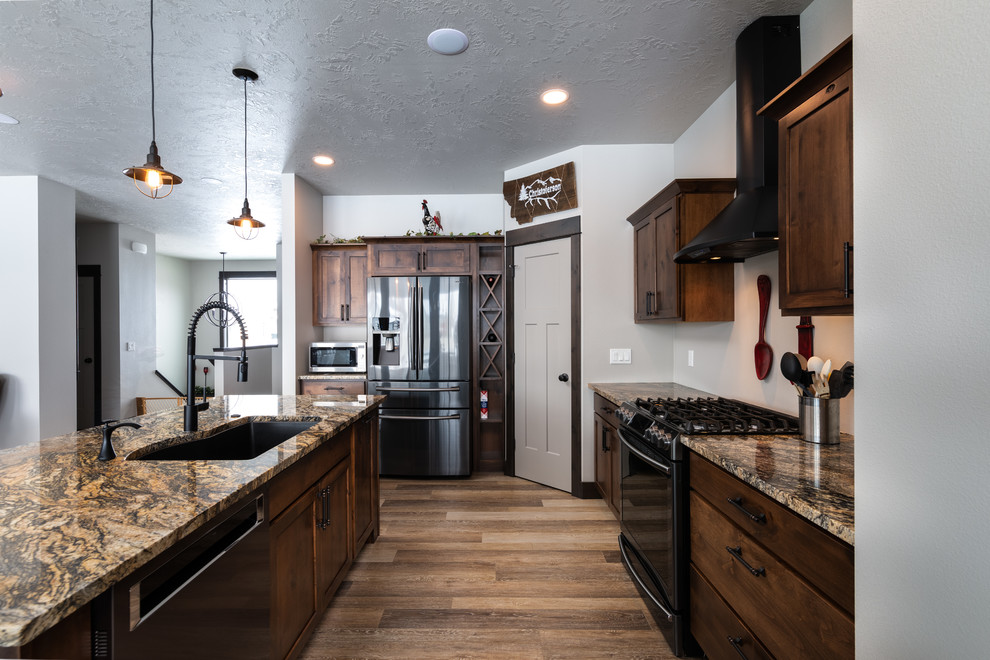 Example of a mid-sized transitional l-shaped medium tone wood floor and brown floor eat-in kitchen design with an undermount sink, shaker cabinets, medium tone wood cabinets, granite countertops, stainless steel appliances, an island and beige countertops
