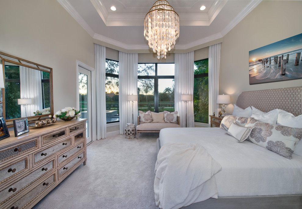 Design ideas for a large transitional master bedroom in Miami with beige walls and carpet.