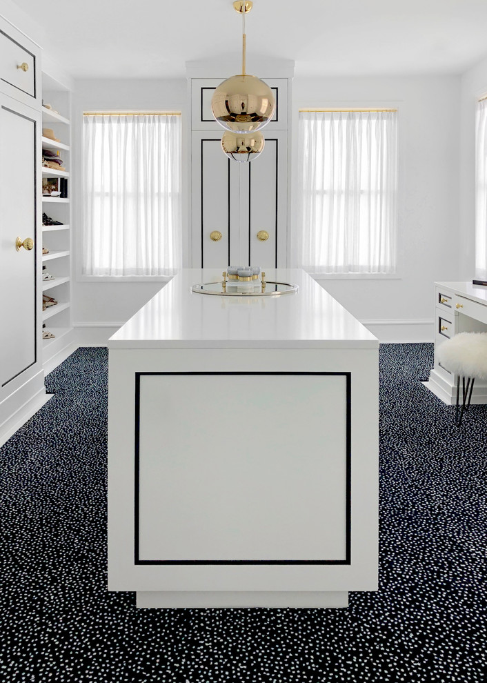 This is an example of an expansive transitional women's walk-in wardrobe in New York with recessed-panel cabinets, white cabinets, carpet and white floor.