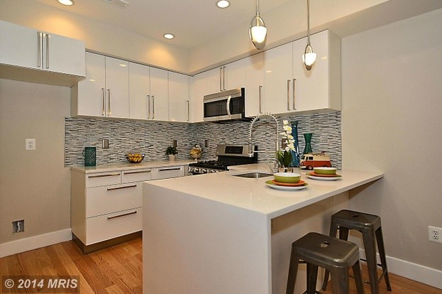 Transitional u-shaped light wood floor eat-in kitchen photo in DC Metro with an undermount sink, flat-panel cabinets, white cabinets, quartz countertops, multicolored backsplash, mosaic tile backsplash, stainless steel appliances and a peninsula