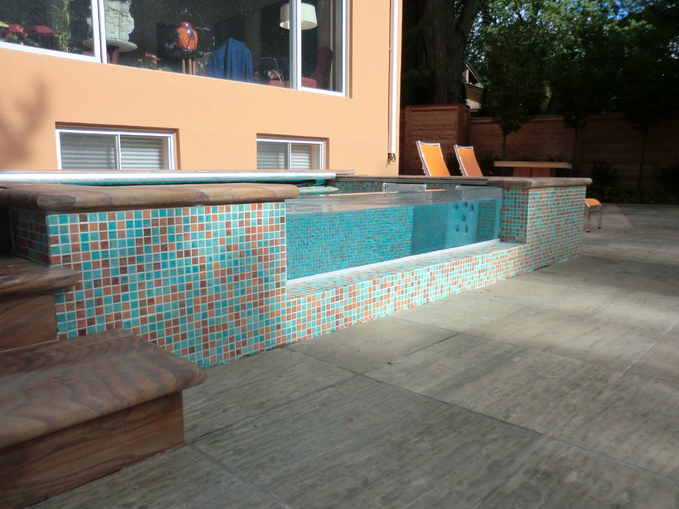Small backyard rectangular aboveground pool in Toronto with a hot tub and natural stone pavers.