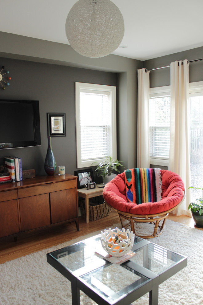 Mid-sized eclectic enclosed living room in Toronto with grey walls and a wall-mounted tv.