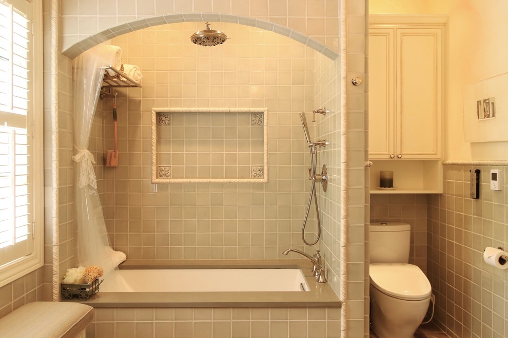 Photo of a mid-sized traditional bathroom in Chicago with white cabinets, beaded inset cabinets, an alcove tub, a shower/bathtub combo, gray tile, ceramic tile, engineered quartz benchtops, a shower curtain, a two-piece toilet, white walls, a trough sink, porcelain floors and brown floor.