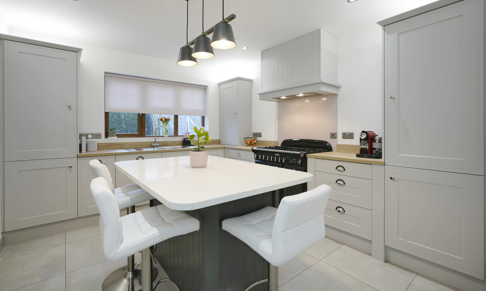 Design ideas for a small traditional l-shaped separate kitchen in Belfast with a single-bowl sink, shaker cabinets, grey cabinets, laminate benchtops, pink splashback, glass sheet splashback, black appliances, ceramic floors, with island, beige floor and brown benchtop.