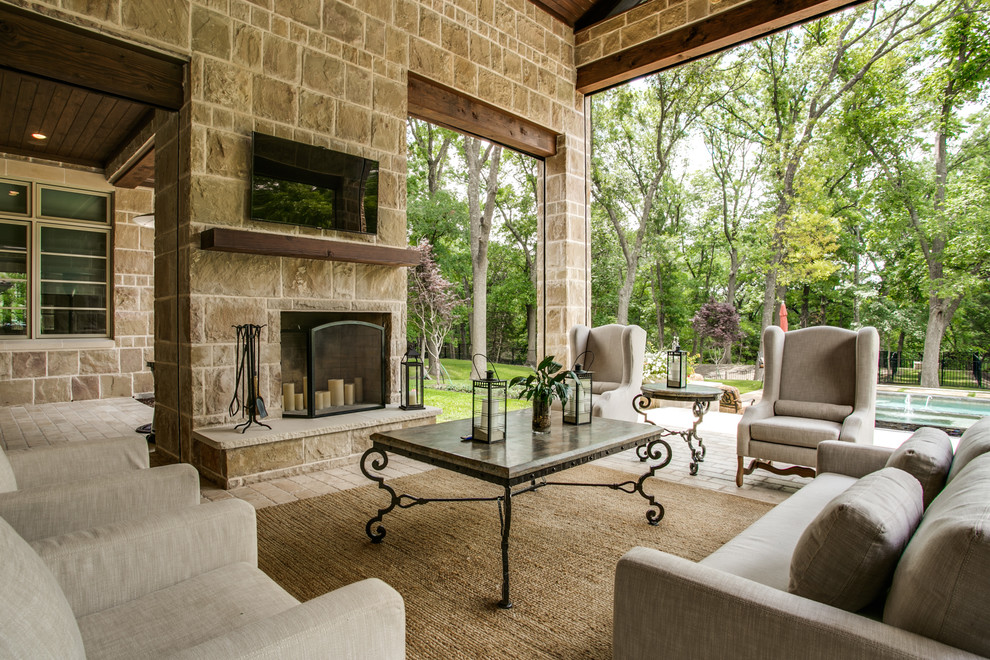 Design ideas for a traditional patio in Dallas with a roof extension and with fireplace.