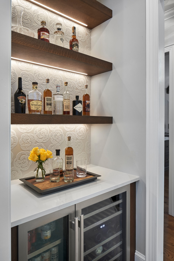 Imagen de bar en casa lineal campestre pequeño sin pila con puertas de armario de madera en tonos medios, encimera de cuarzo compacto, salpicadero blanco y encimeras blancas