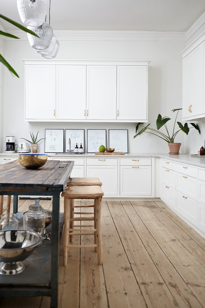 Large scandinavian l-shaped eat-in kitchen in Aarhus with with island, shaker cabinets and white cabinets.