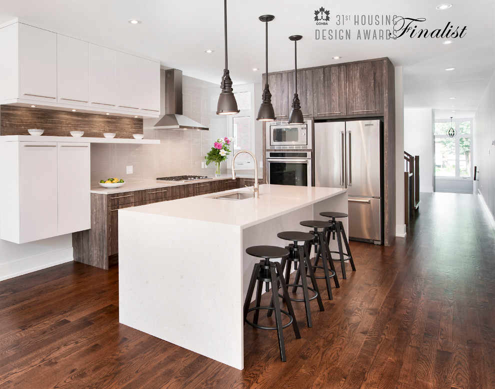 Inspiration for a small modern l-shaped open plan kitchen in Ottawa with an undermount sink, flat-panel cabinets, white cabinets, quartz benchtops, grey splashback, stainless steel appliances, dark hardwood floors, with island and ceramic splashback.
