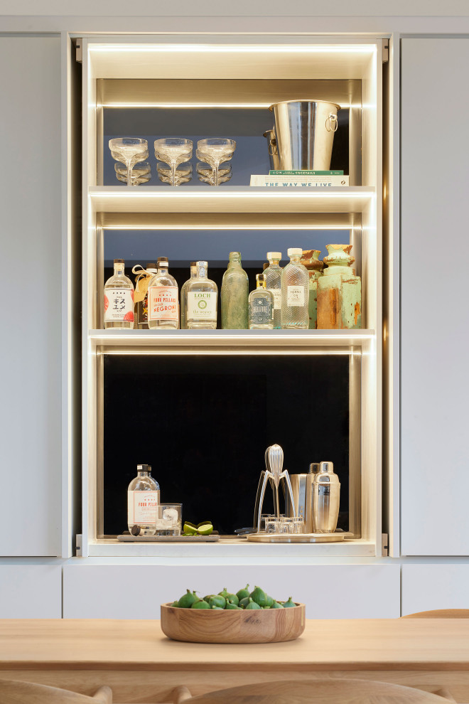 メルボルンにあるコンテンポラリースタイルのおしゃれなホームバー (白いキャビネット、ミラータイルのキッチンパネル) の写真