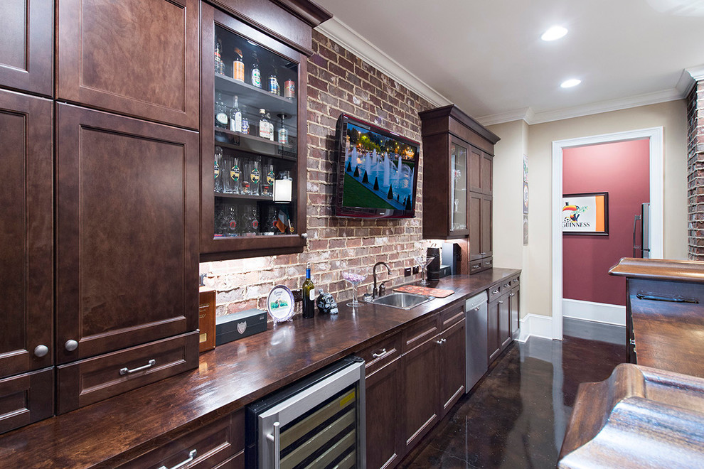 Inspiration for a mid-sized traditional single-wall home bar in Atlanta with a drop-in sink, beaded inset cabinets, dark wood cabinets, wood benchtops, red splashback, concrete floors and terra-cotta splashback.