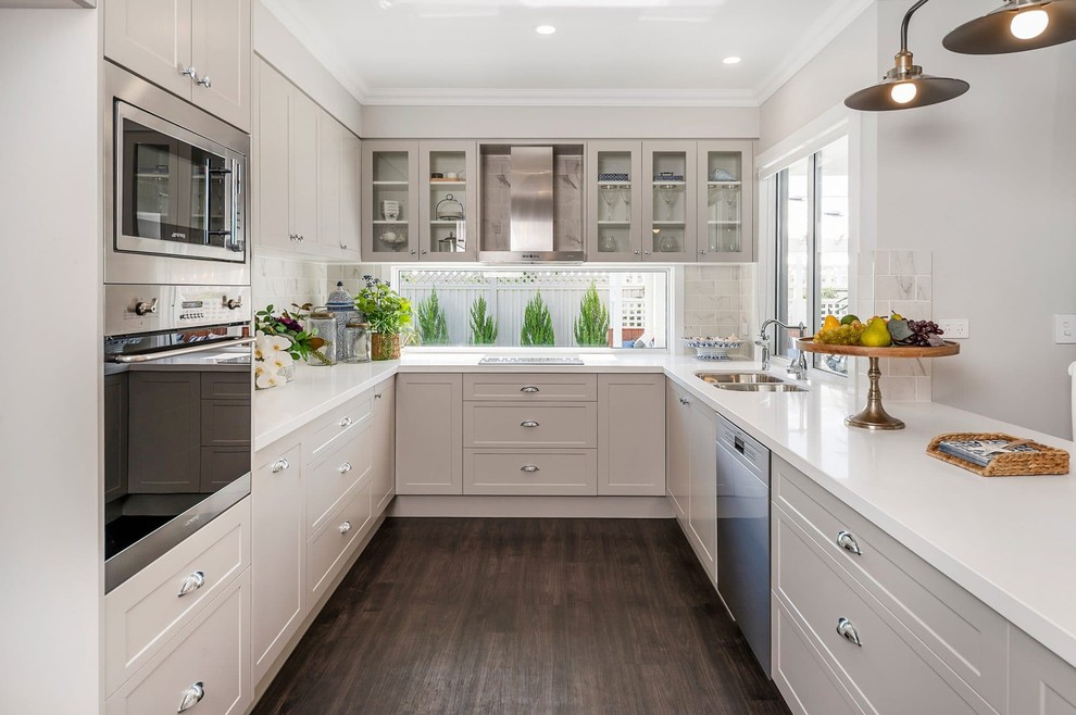 Inspiration for a mid-sized traditional u-shaped kitchen in Brisbane with recessed-panel cabinets, beige cabinets, quartz benchtops, window splashback, stainless steel appliances, dark hardwood floors, brown floor, an undermount sink, white benchtop and no island.