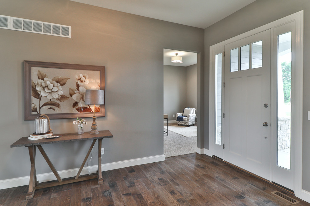 Photo of a mid-sized transitional foyer in St Louis with grey walls, dark hardwood floors, a single front door, a white front door and brown floor.