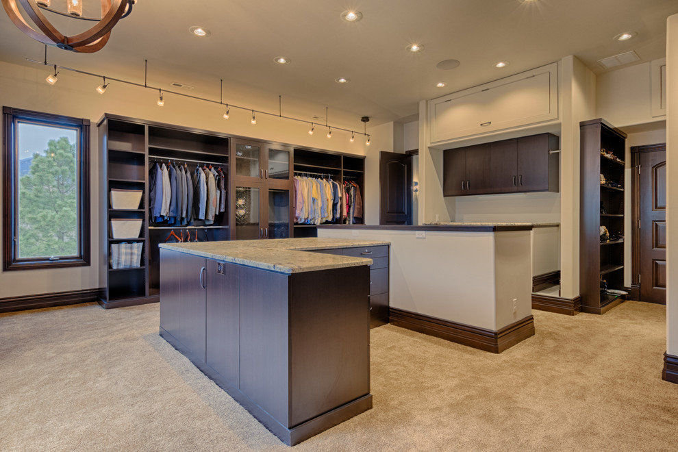 Inspiration for an expansive contemporary gender-neutral dressing room in Denver with flat-panel cabinets, medium wood cabinets and carpet.