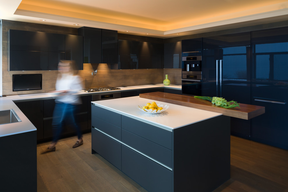 Inspiration for a large modern u-shaped eat-in kitchen in Seattle with an undermount sink, flat-panel cabinets, brown cabinets, quartz benchtops, brown splashback, stainless steel appliances, medium hardwood floors, with island, brown floor and white benchtop.
