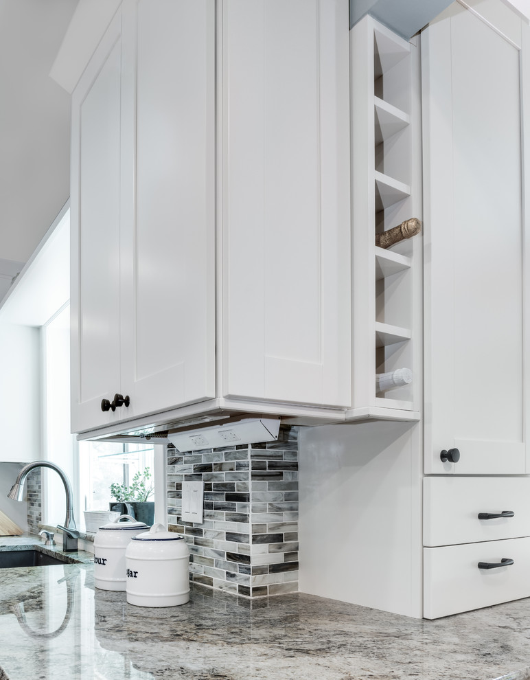 Inspiration for a mid-sized transitional galley medium tone wood floor and brown floor eat-in kitchen remodel in Denver with an undermount sink, shaker cabinets, white cabinets, granite countertops, blue backsplash, glass tile backsplash, stainless steel appliances, an island and beige countertops
