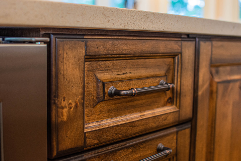 Inspiration for a mid-sized rustic u-shaped light wood floor and beige floor eat-in kitchen remodel with an undermount sink, raised-panel cabinets, distressed cabinets, quartz countertops, beige backsplash, wood backsplash, stainless steel appliances, an island and beige countertops