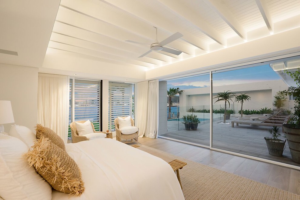 Design ideas for an expansive beach style master bedroom in Central Coast with white walls and grey floor.