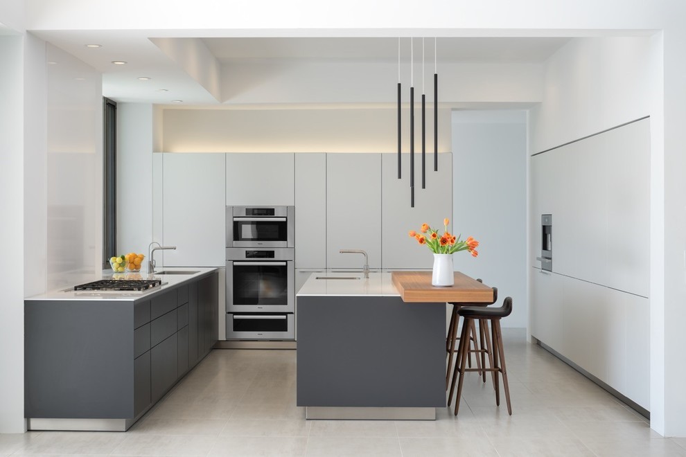 Design ideas for a mid-sized u-shaped kitchen in Phoenix with flat-panel cabinets, white cabinets, quartz benchtops, porcelain floors, with island, white splashback, white floor, porcelain splashback, an undermount sink, panelled appliances and white benchtop.