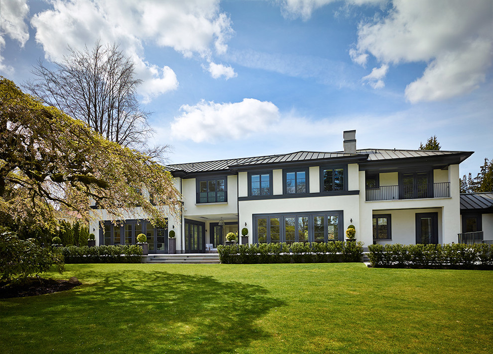 This is an example of a large transitional two-storey stucco white exterior in Seattle.