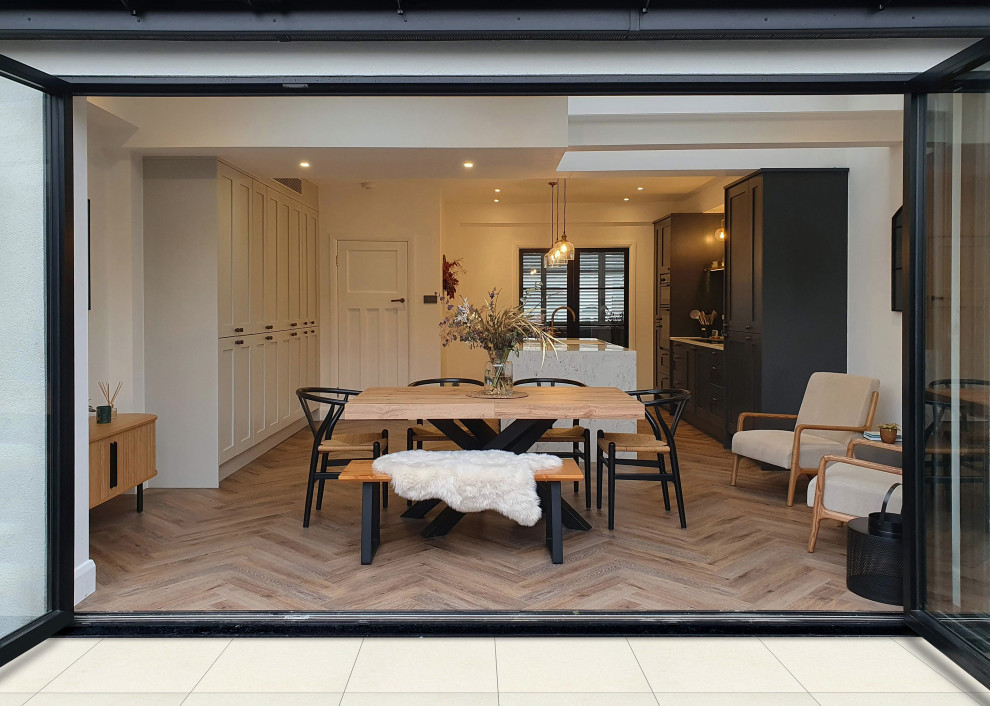 Medium sized modern single-wall open plan kitchen in London with a submerged sink, shaker cabinets, blue cabinets, composite countertops, white splashback, marble splashback, integrated appliances, light hardwood flooring, an island, brown floors and white worktops.