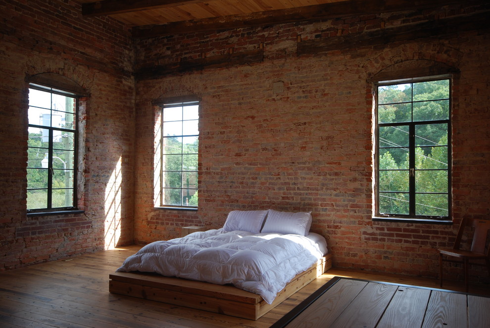 Design ideas for an industrial bedroom in Atlanta with medium hardwood floors.