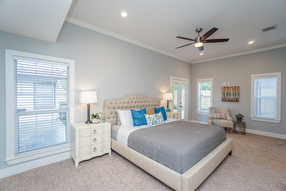 Inspiration for a large beach style master bedroom in Houston with grey walls, carpet, no fireplace and beige floor.